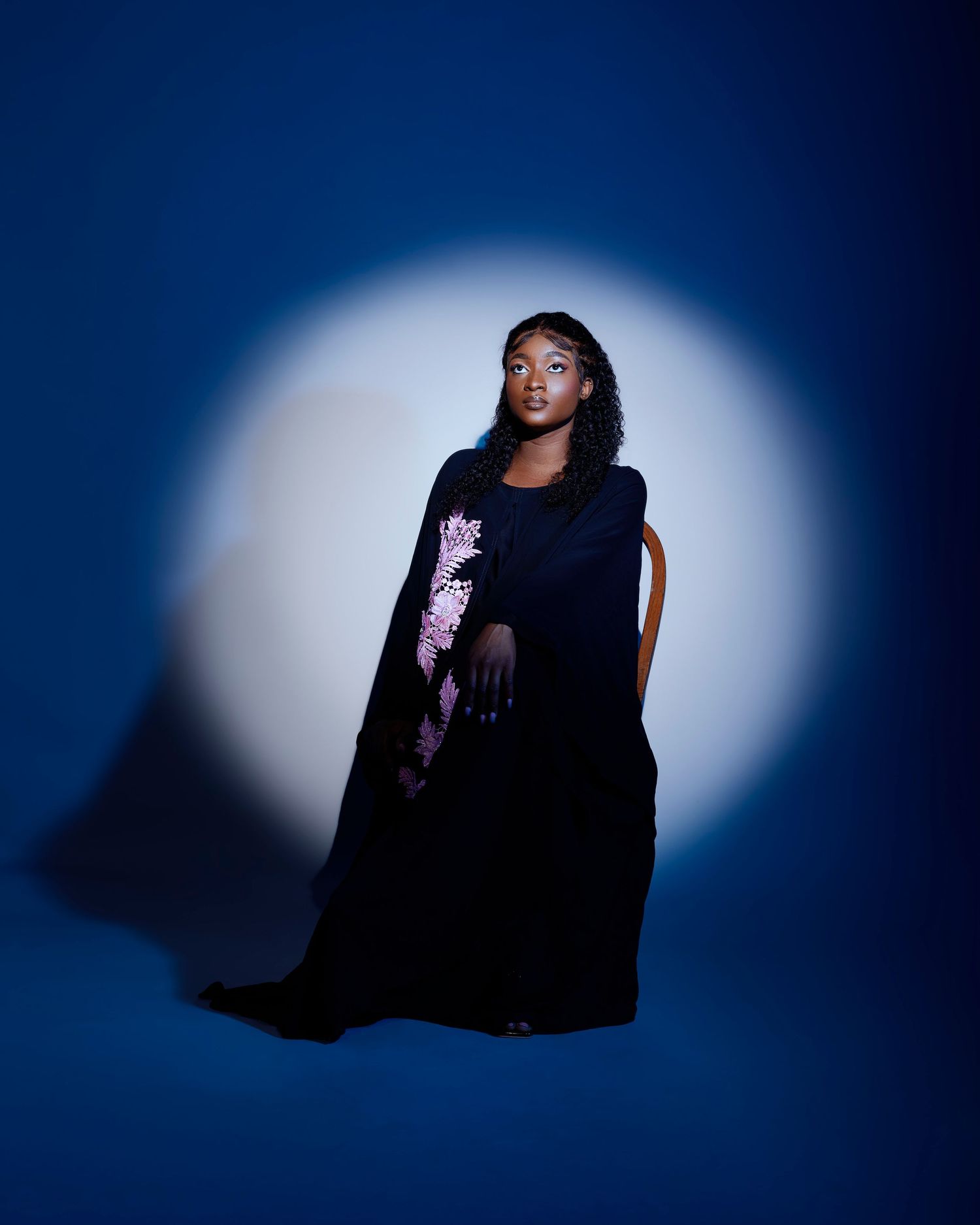 Dramatic studio portraits with moody lighting against a deep blue background.