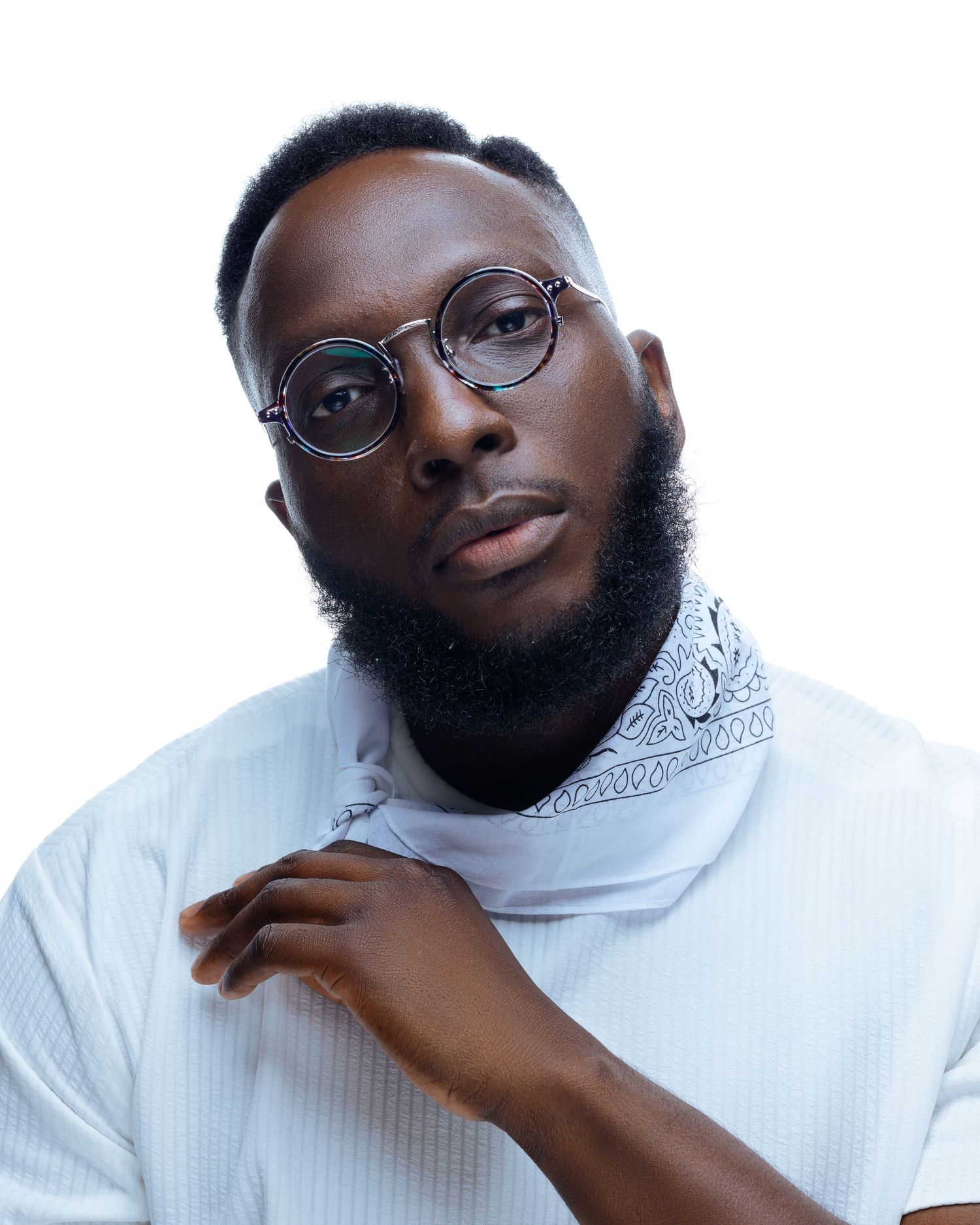 Professional headshots of person wearing white turtleneck sweater and glasses against light background.