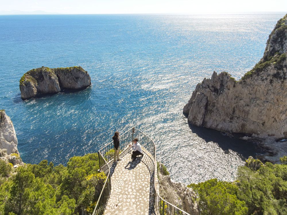 Panoramic view of Mediterranean coastline with dramatic cliffs and blue waters.