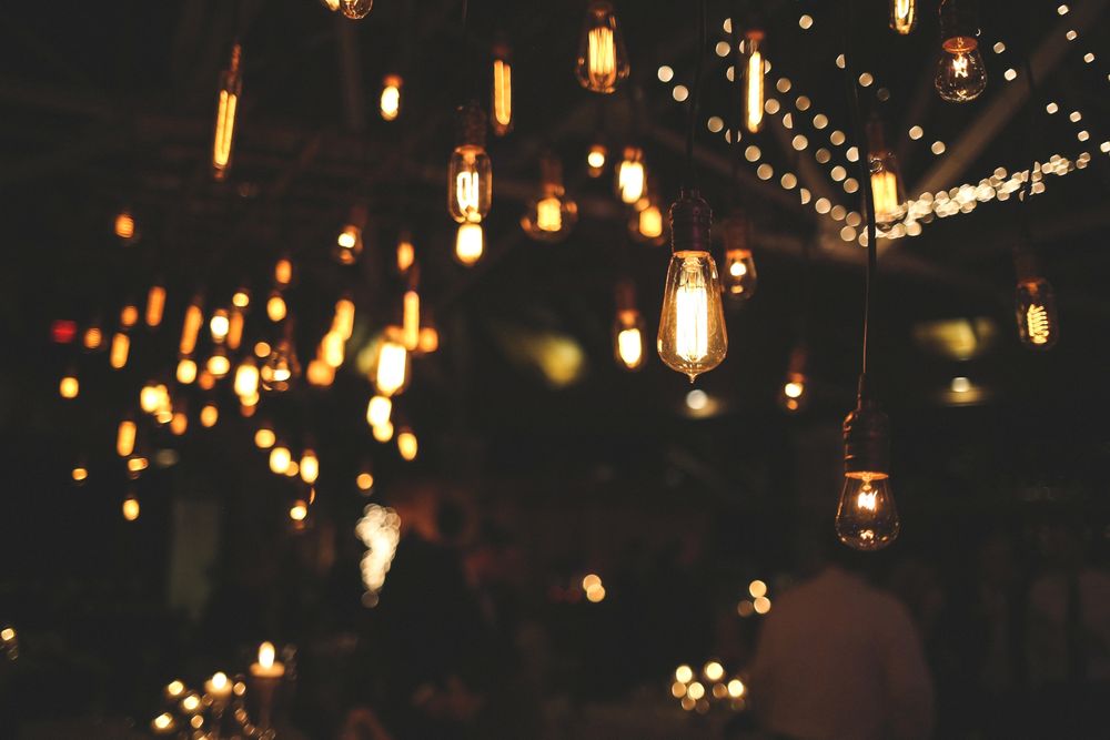 Glowing vintage light bulbs and lanterns create a magical ambiance in a dark setting.