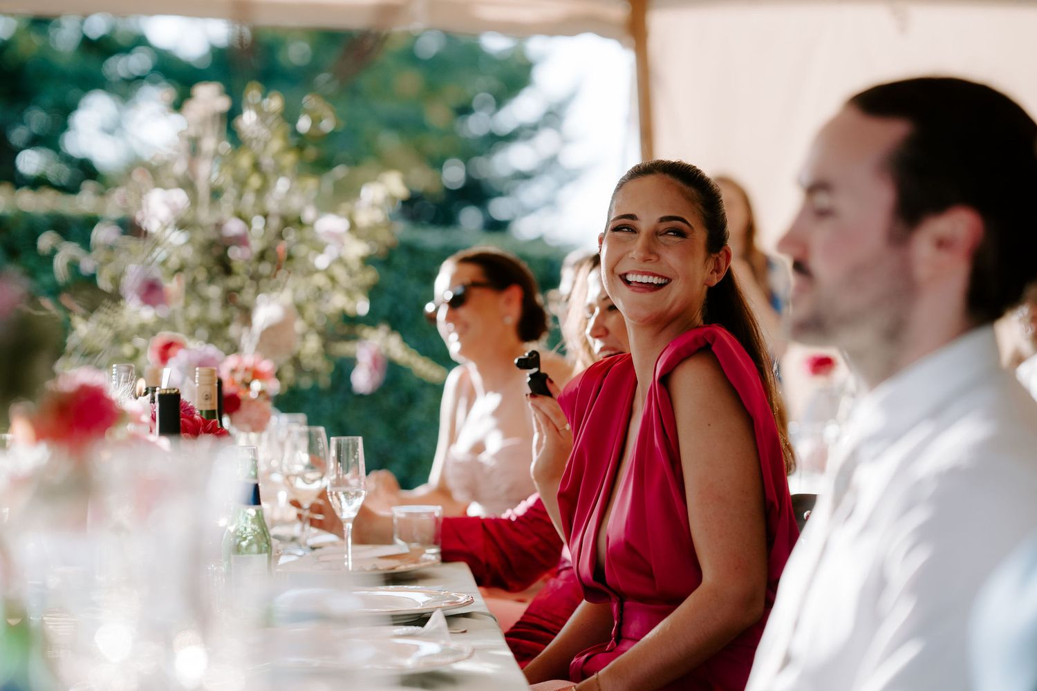 bridesmaid laughing at father of the bride speech at wedding in marquee in islip in Oxfordshire