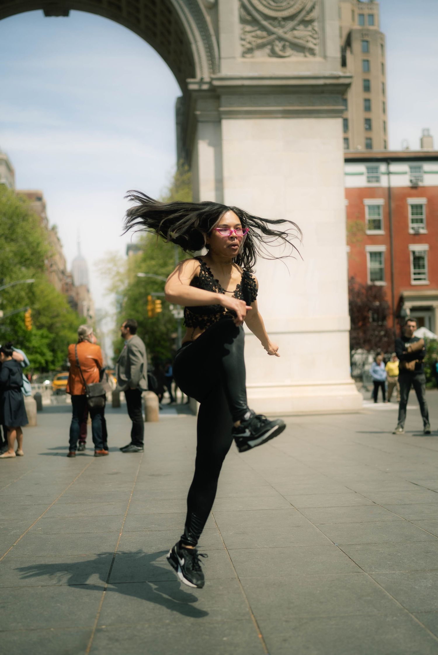 Dynamic dance sequence showing fluid movement against an urban backdrop with dramatic hair motion.