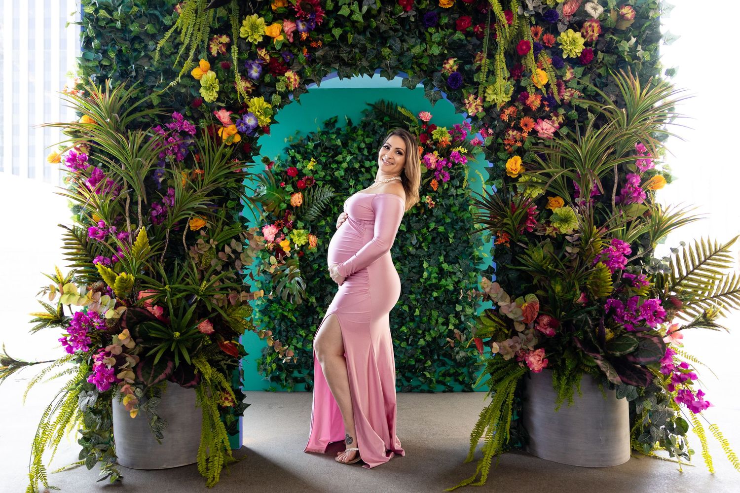 Pregnant mother standing in front of floral display