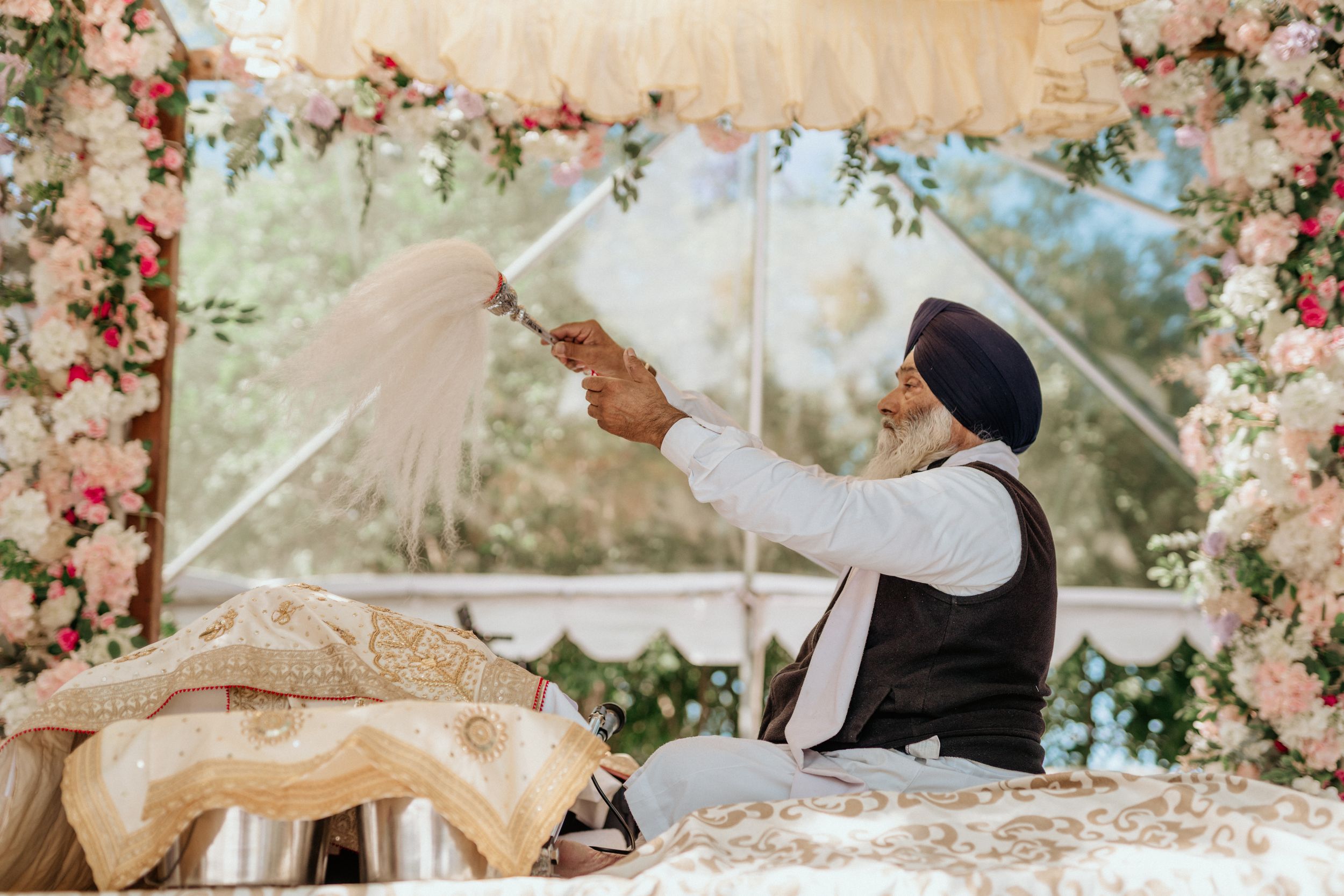 Traditional ceremony under floral arch with soft pink and white decorations.