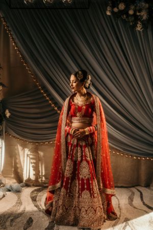 A stunning red and gold Indian lehenga with intricate embroidery in an elegant setting.
