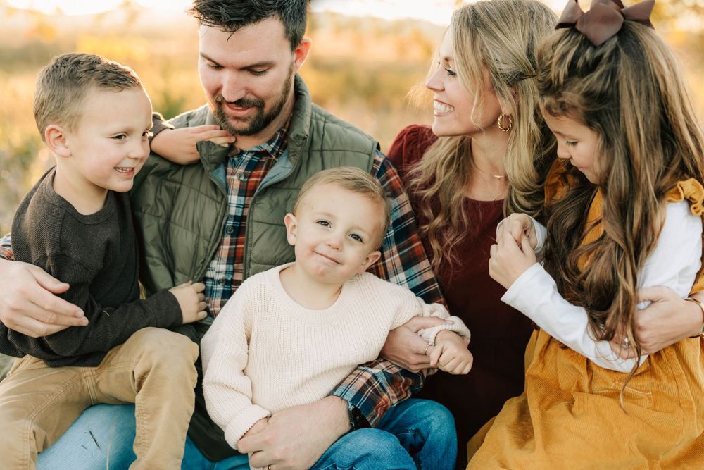 Candid family moment captured during fall photo session outdoors.