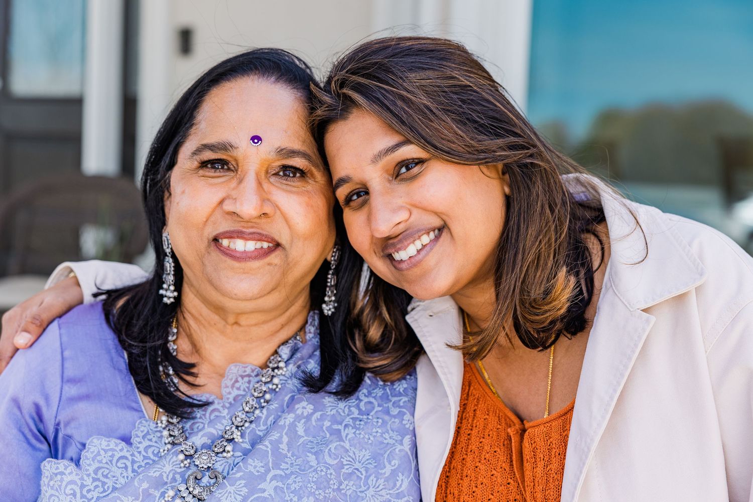 Close-up outdoor portrait of two people sharing a warm embrace.