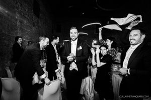 Black and white candid shots of wedding guests laughing and socializing at a reception.