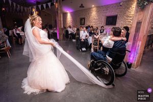 Wedding reception venue with purple uplighting and festive bunting decorations.