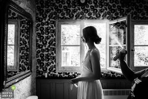 Black and white images of a room with ornate wallpaper and natural window light.