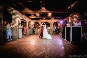 Panoramic view of a rustic reception venue with ambient lighting and exposed wooden beams.