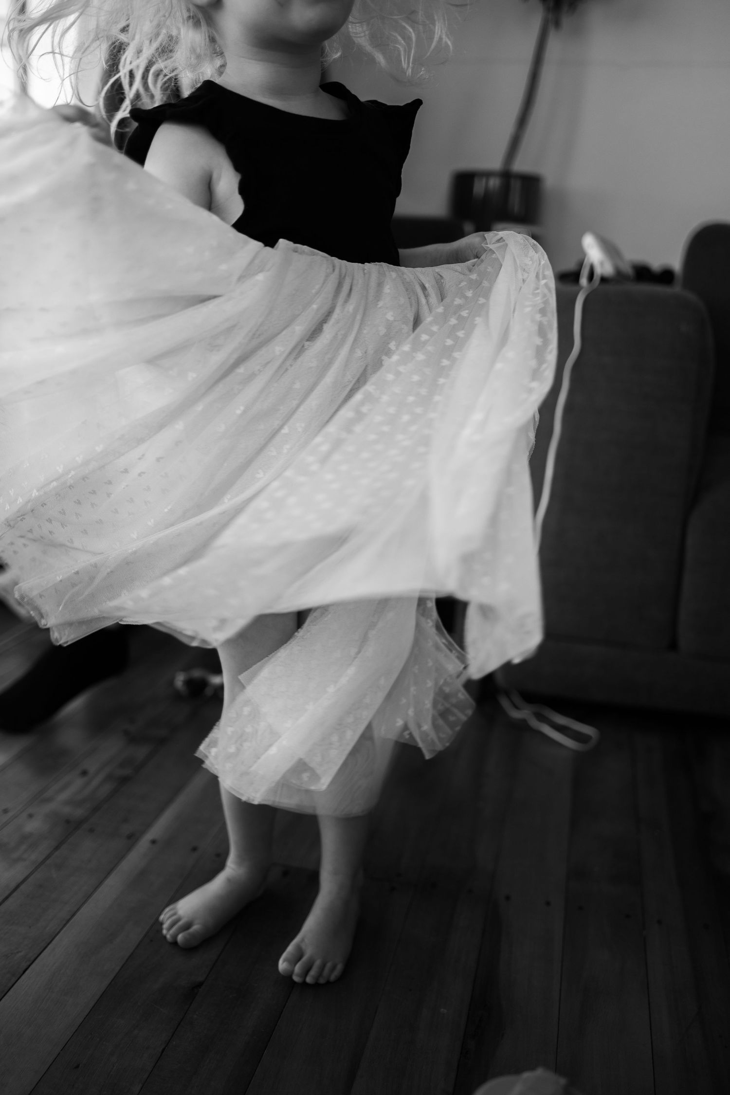 Black and white image of a girl twirling around in a tutu.