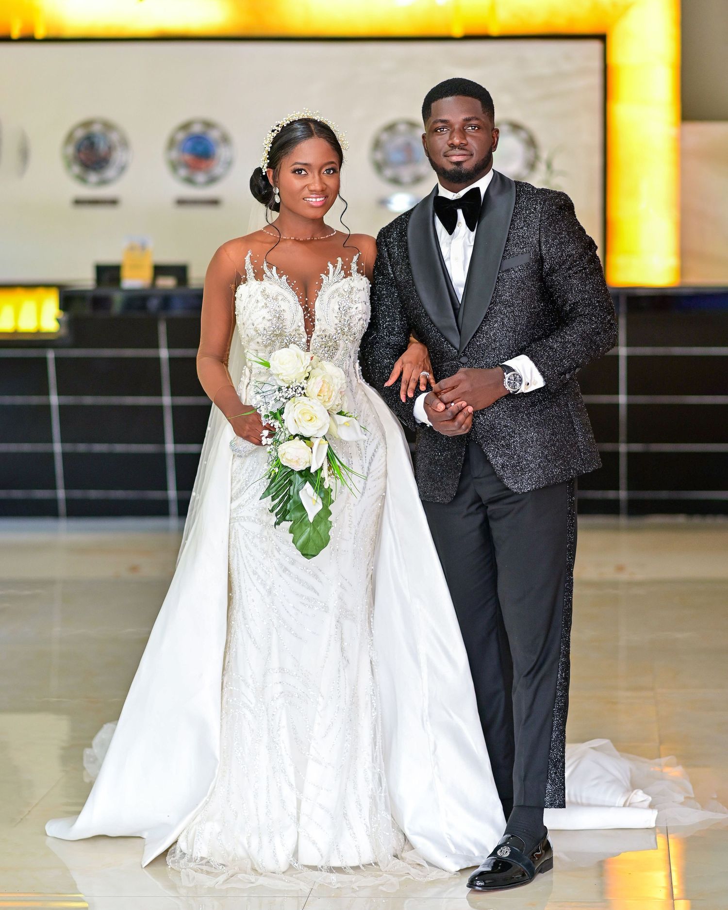 Elegant wedding portraits featuring white lace gown and dark tuxedo in formal setting.