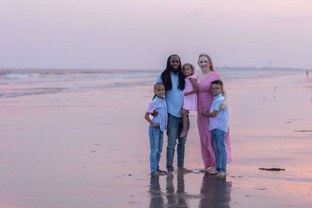 a family of five standing in the sand at sunset at 58th street beach in ocean city new jersey
