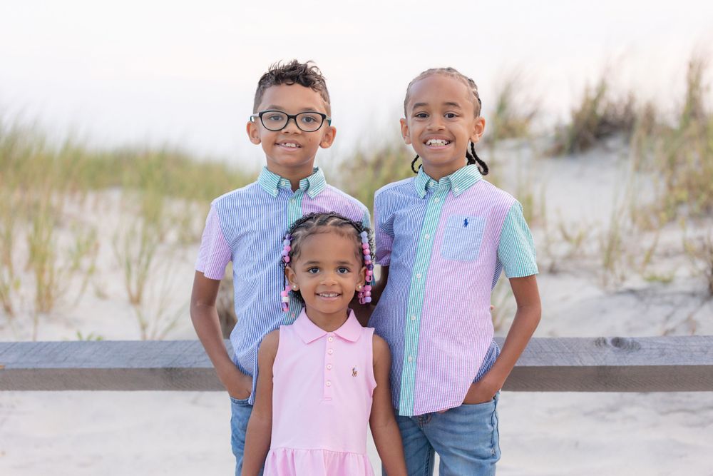 three children standing in front of a fence on the dunes at 58th street beach in ocean city new jersey