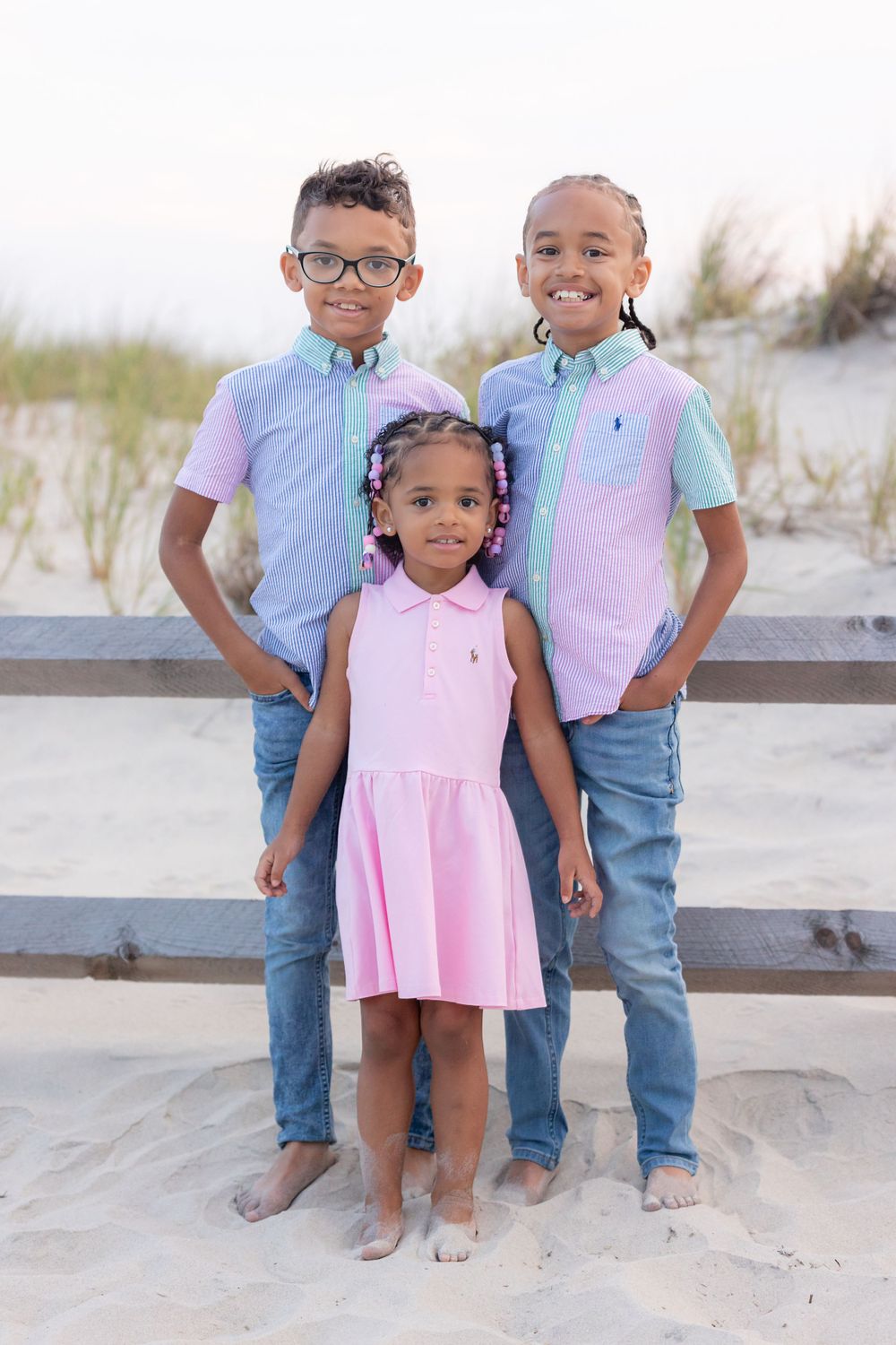 three children standing in front of a fence on the dunes at 58th street beach in ocean city new jersey