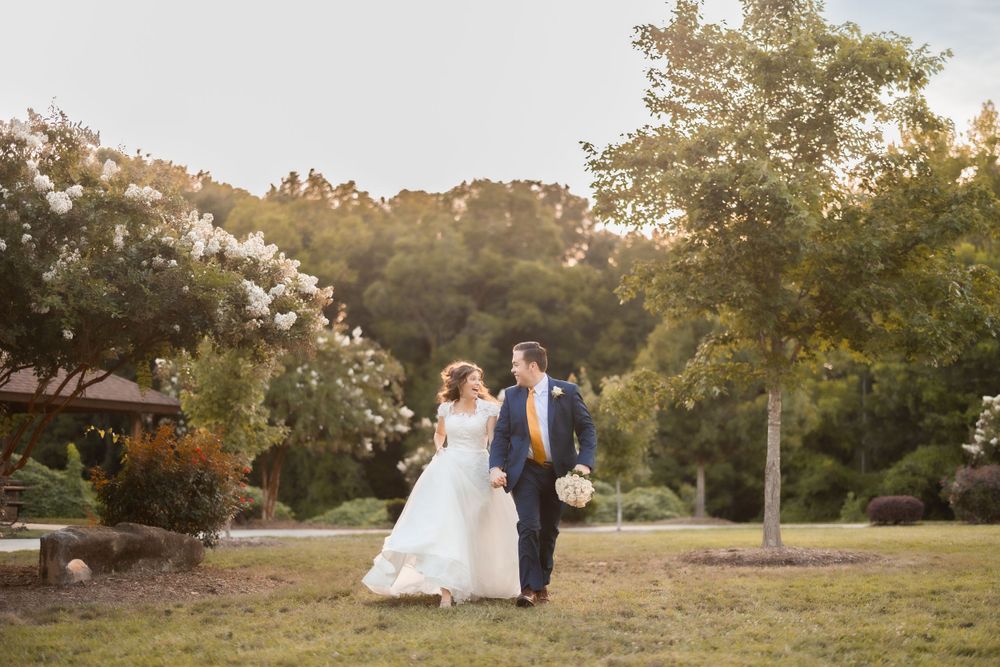 A couple walking through a garden setting during golden hour.