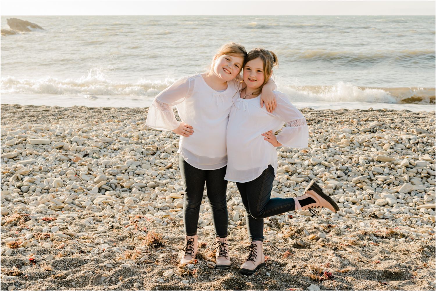 sisters hugging with pink boots for family photo session on the central coast beaches family photos