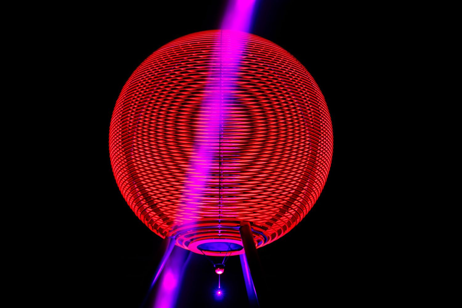 A glowing red circular light pattern with a purple beam creates a hypnotic visual effect.