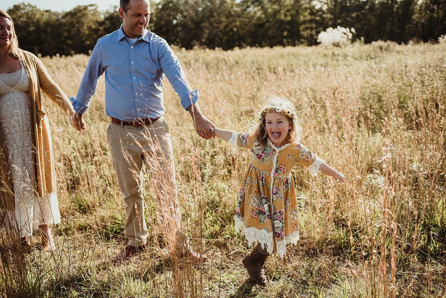 A joyful moment in a sun-drenched field with tall grass and wildflowers.