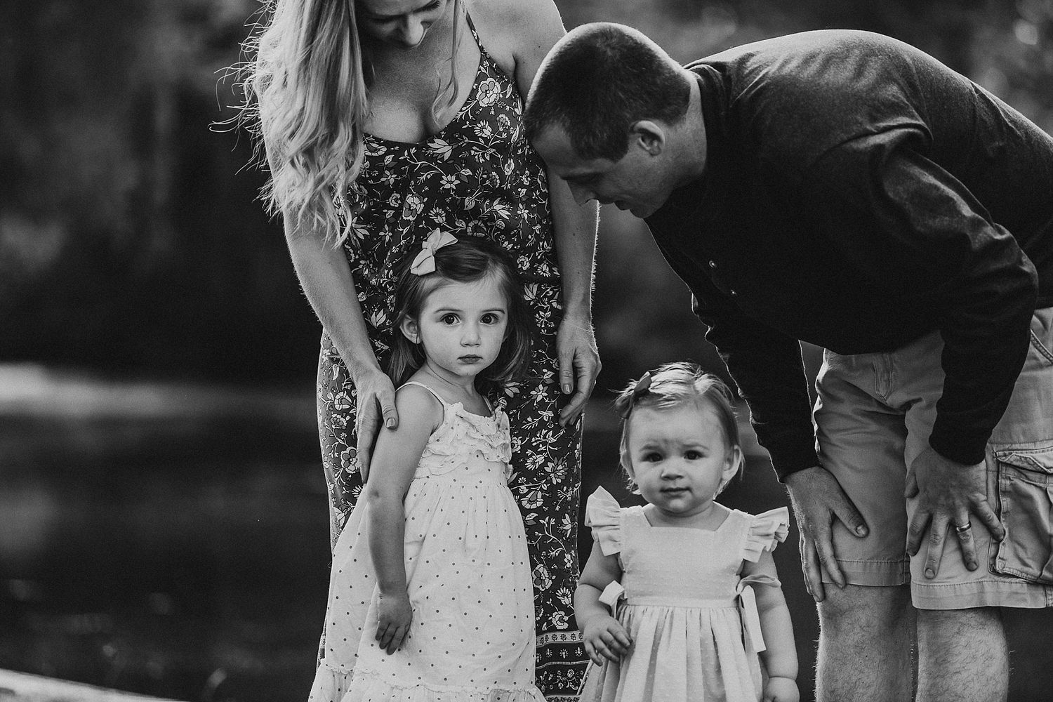 Black and white family portrait captured in intimate outdoor setting.