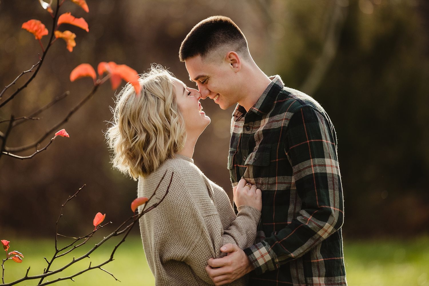 A romantic autumn moment captured between a couple among orange leaves in golden light.