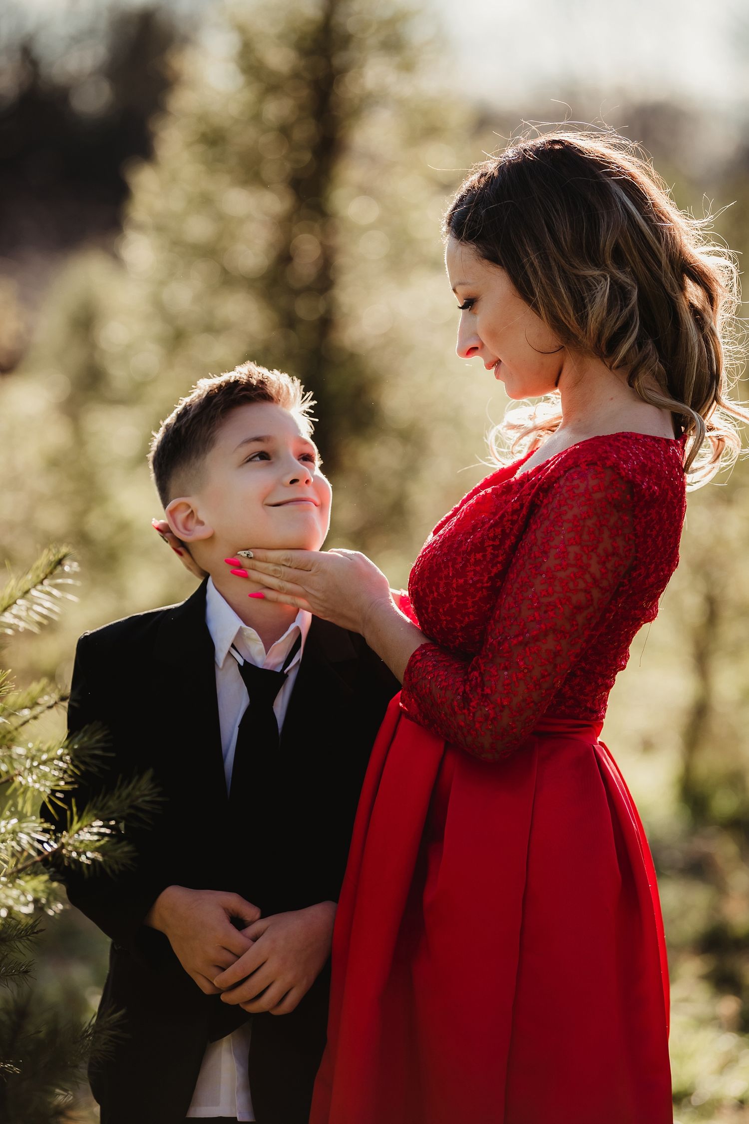 A tender moment between two people in formal wear captured in warm sunlight.
