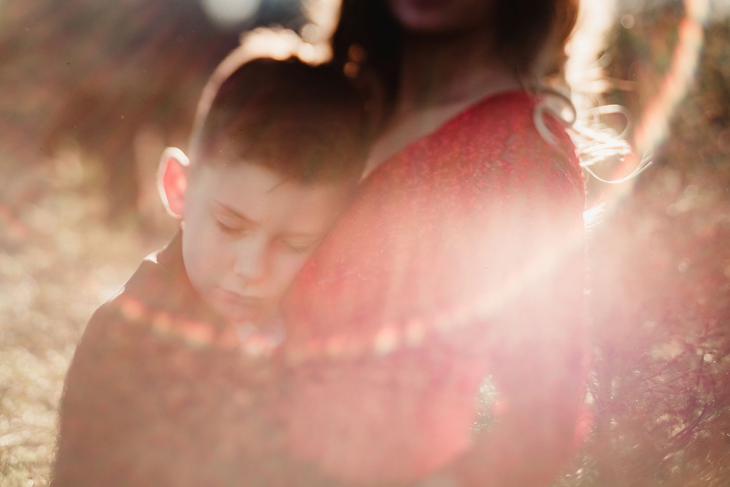 A dreamy sun-lit portrait captured with soft focus and lens flare effects creating a magical atmosphere.