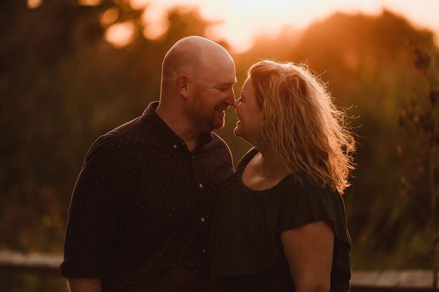 Romantic sunset portrait of a couple sharing an intimate moment in golden light.