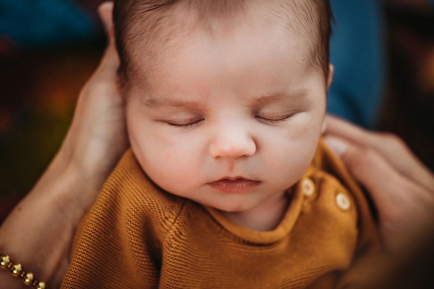 Baby wearing mustard yellow outfit sleeping peacefully.