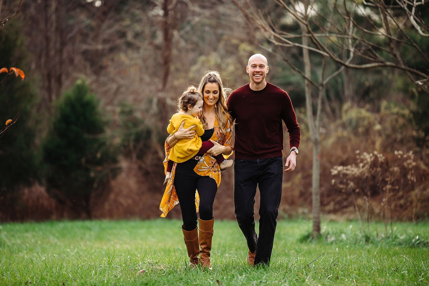 Family walking together through a grassy field on an autumn day.