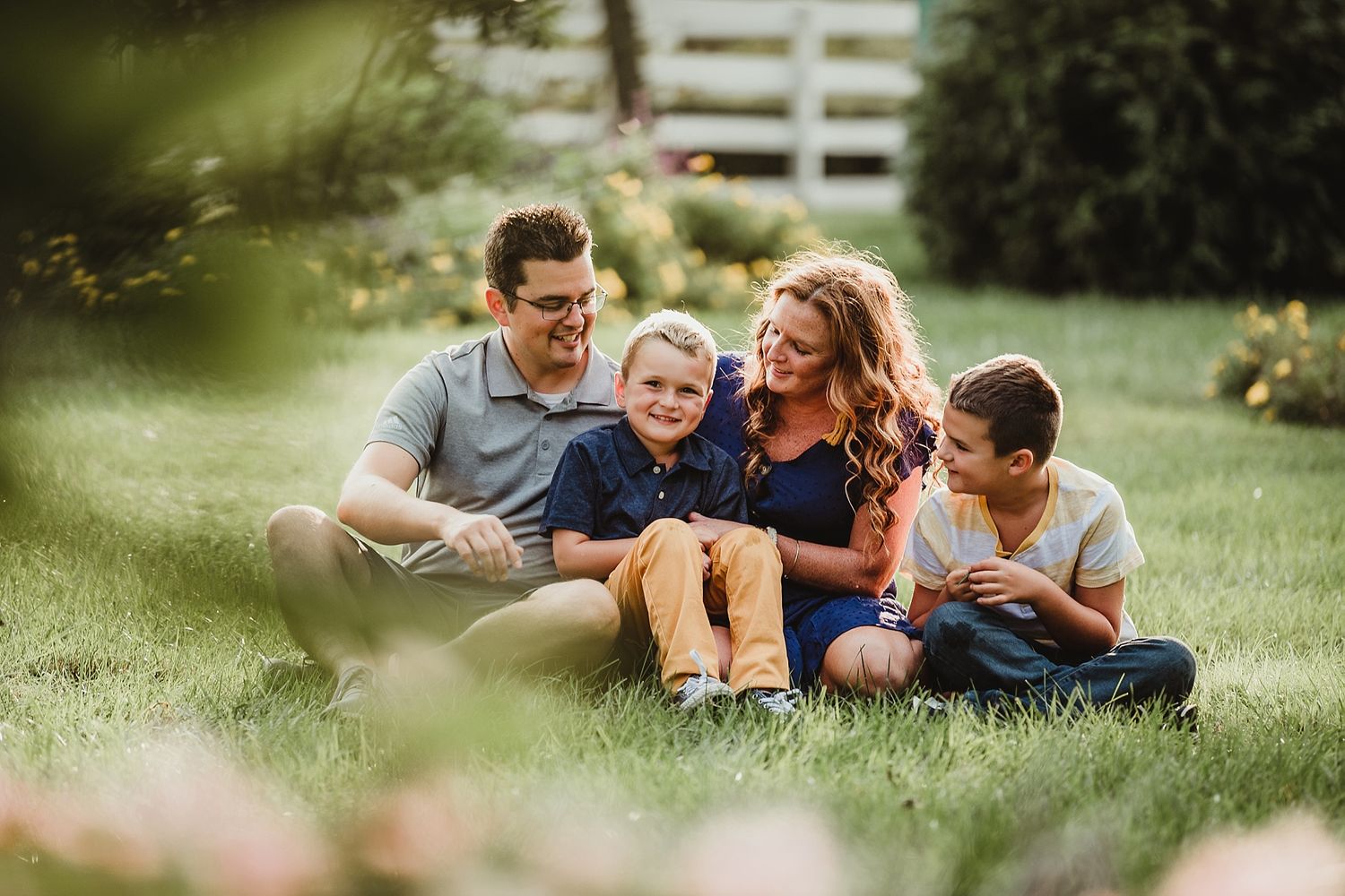 Family sitting together on grass enjoying quality time outdoors.