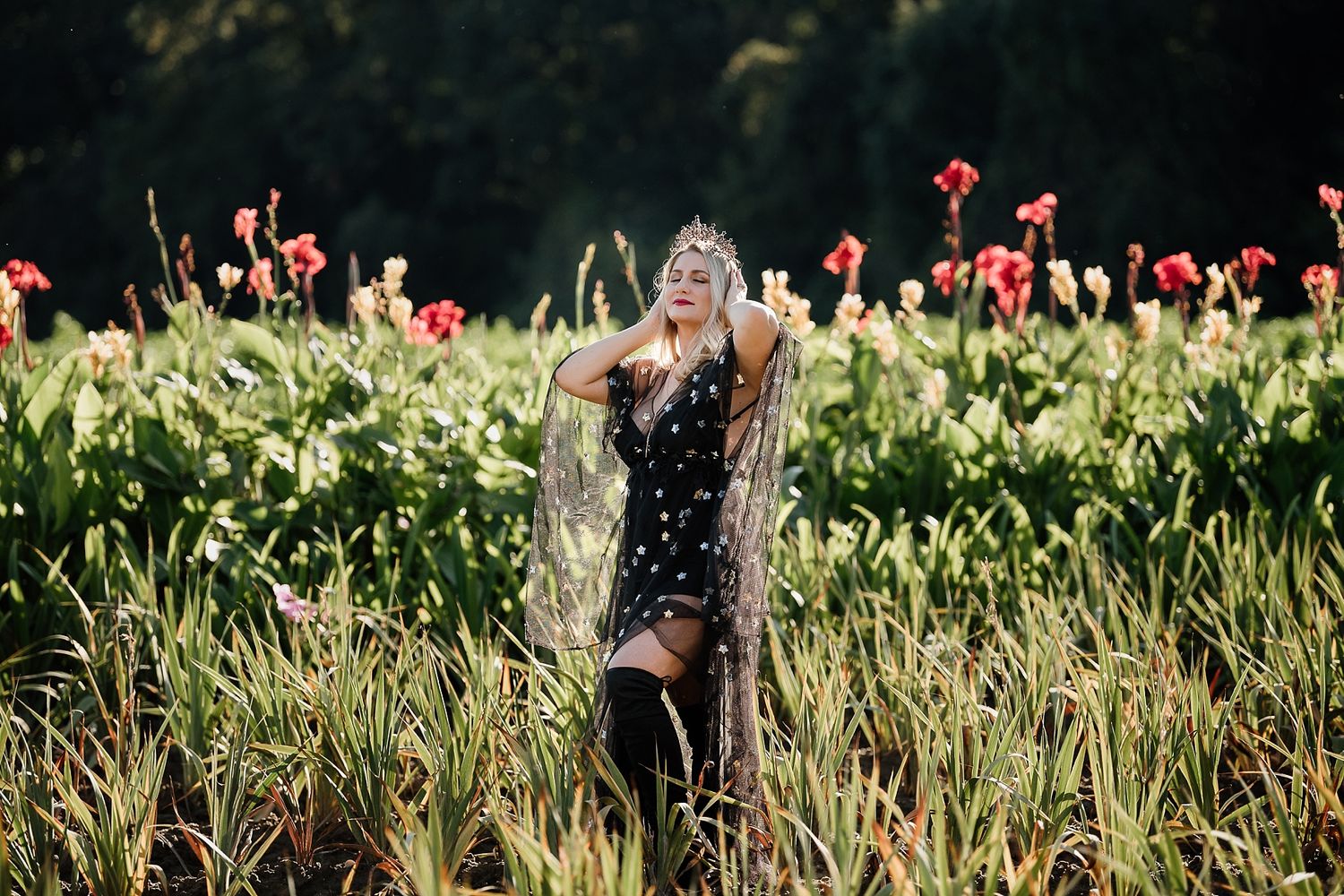 A polka dot dress stands out against vibrant red flowers in a sunny garden setting.