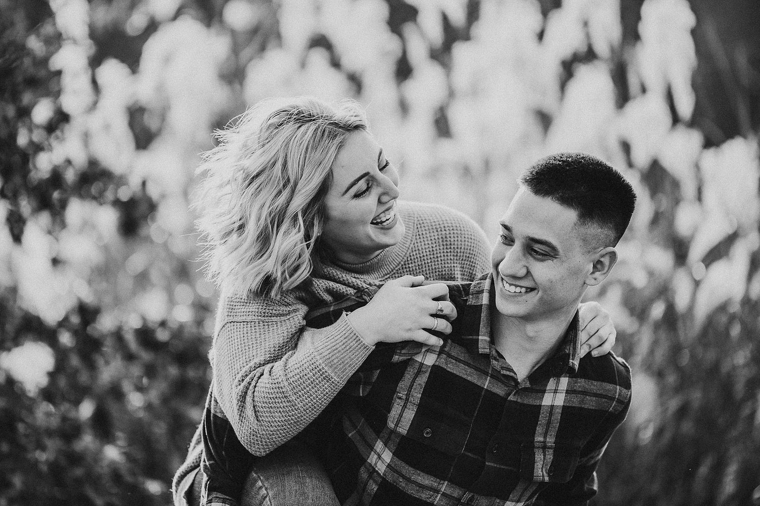 Couple sharing intimate laughter together in black and white portrait outdoors.