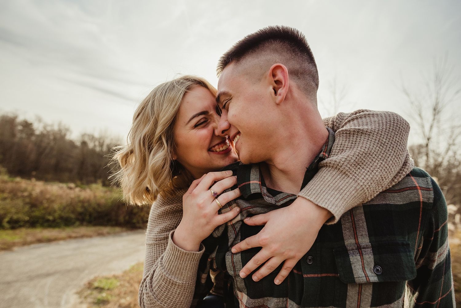 Intimate close-up of couple sharing tender moment on country road.