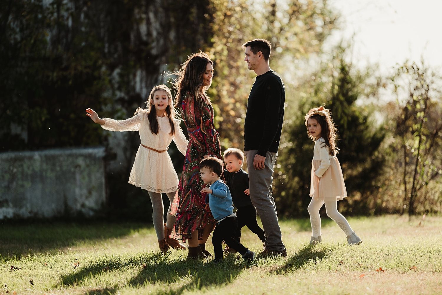 A family plays together in a sunlit field on a warm afternoon.