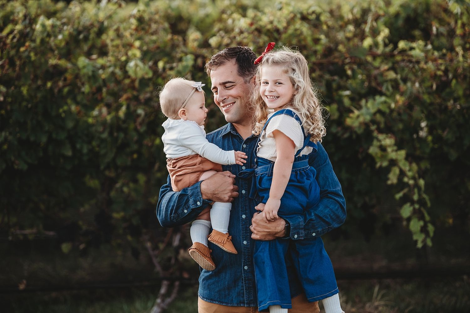 A joyful outdoor portrait with children against lush greenery.