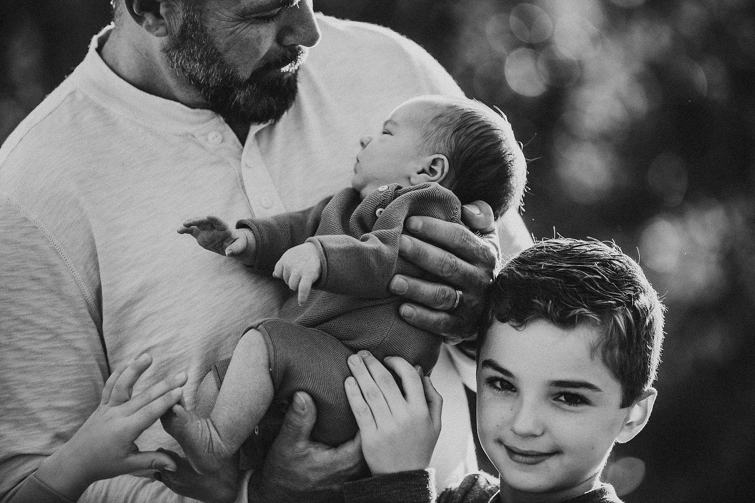 A tender family moment captured in black and white with a newborn.