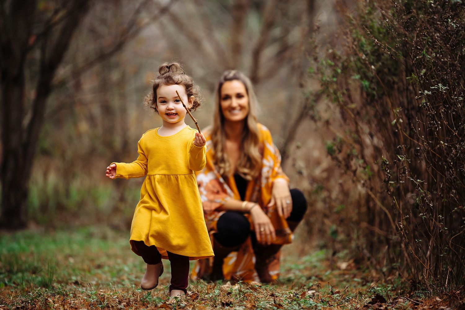 A joyful moment captured outdoors with vibrant yellow clothing against an autumn backdrop.