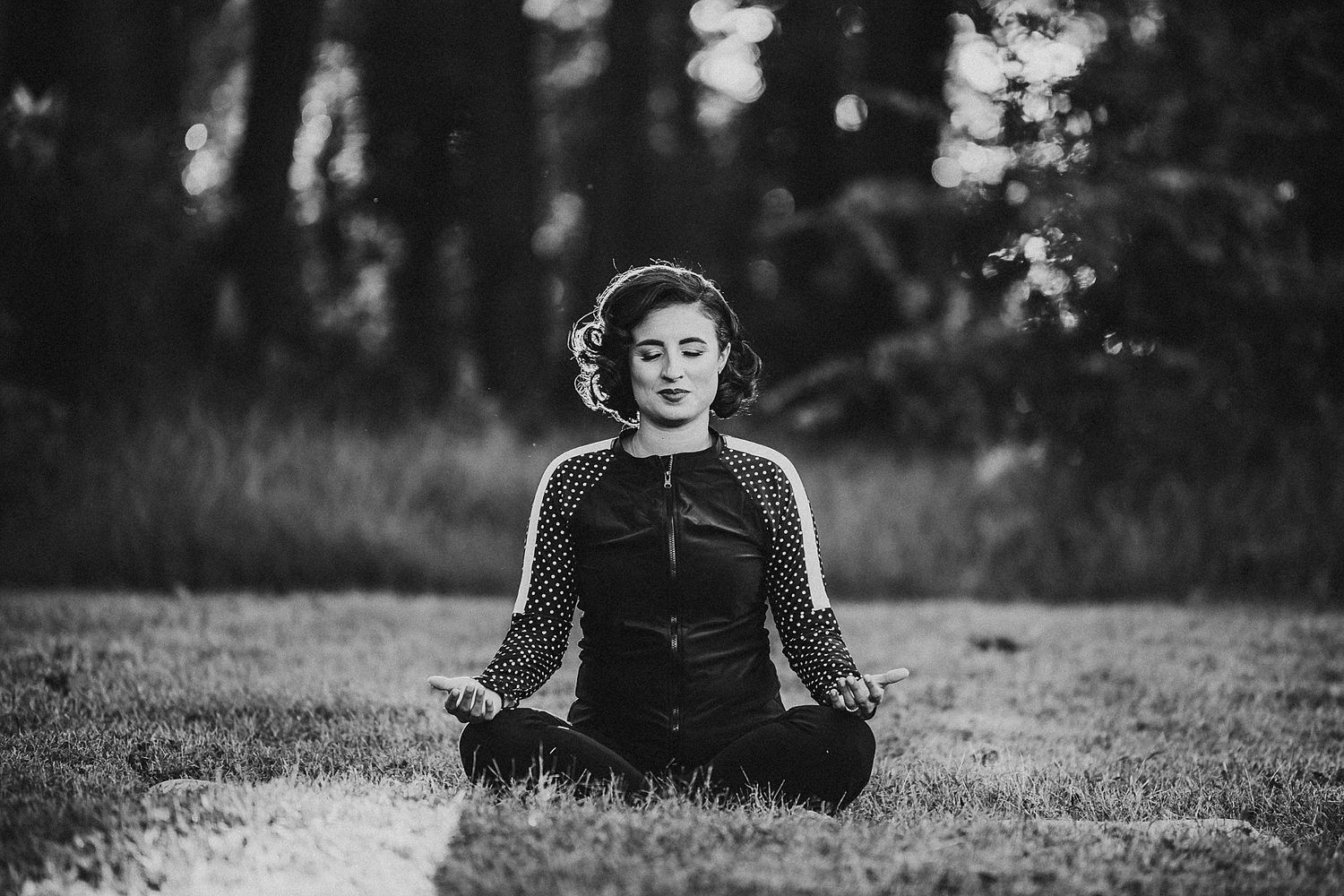 A peaceful black and white image of meditation in a serene outdoor setting.