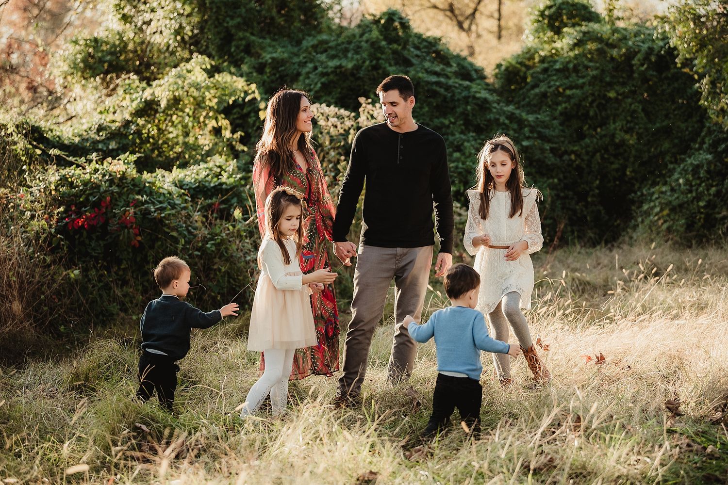 A family enjoying time together in a sunlit field during golden hour.