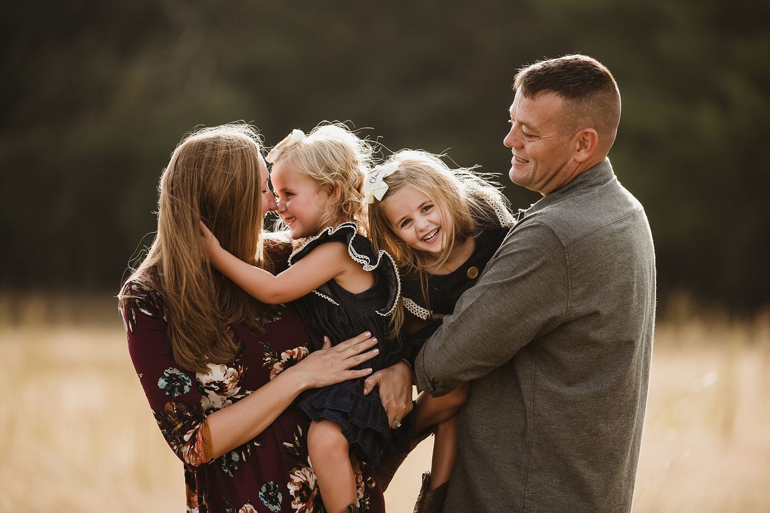 A joyful family moment captured during golden hour in a field.