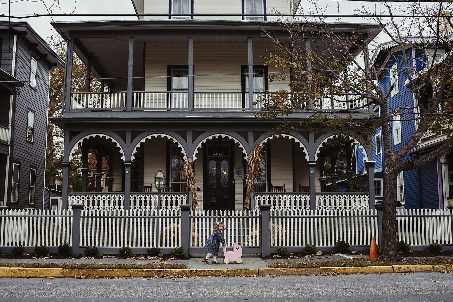 Historic Victorian house with ornate white trim and wraparound porch.