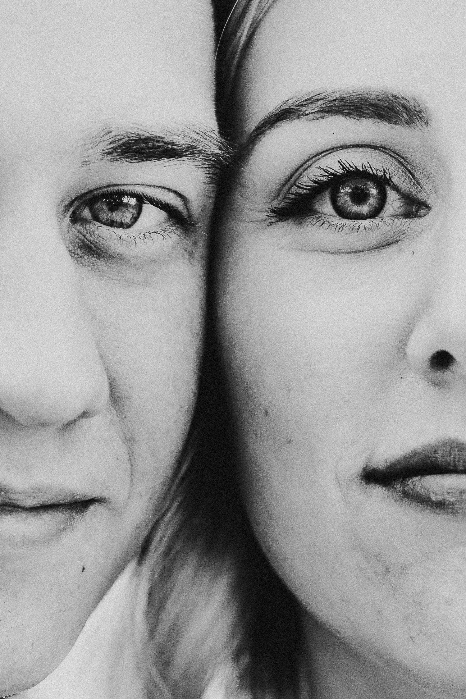 Artistic close-up portrait of two faces merged together in black and white.