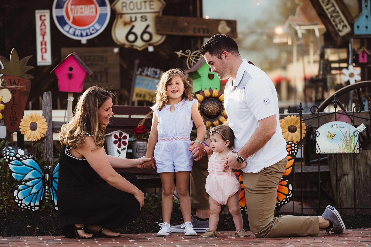 A family interacts near Route 66 memorabilia and a decorative butterfly.
