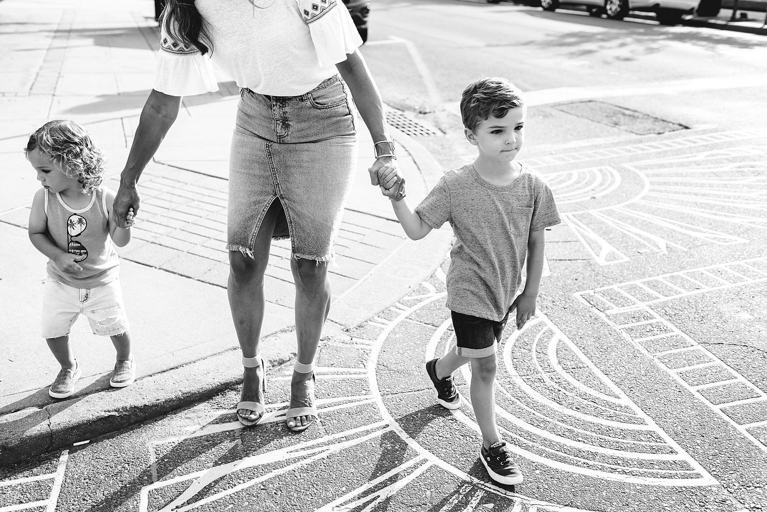 People walking together on a decorative spiral pattern painted on concrete outdoors.