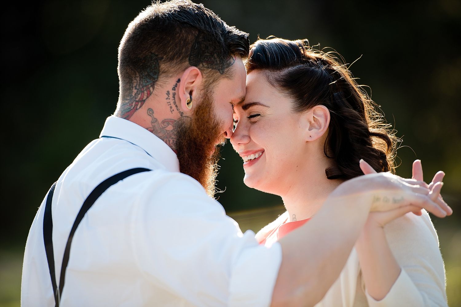 A romantic moment between a couple in formal wear backlit by golden sunlight.