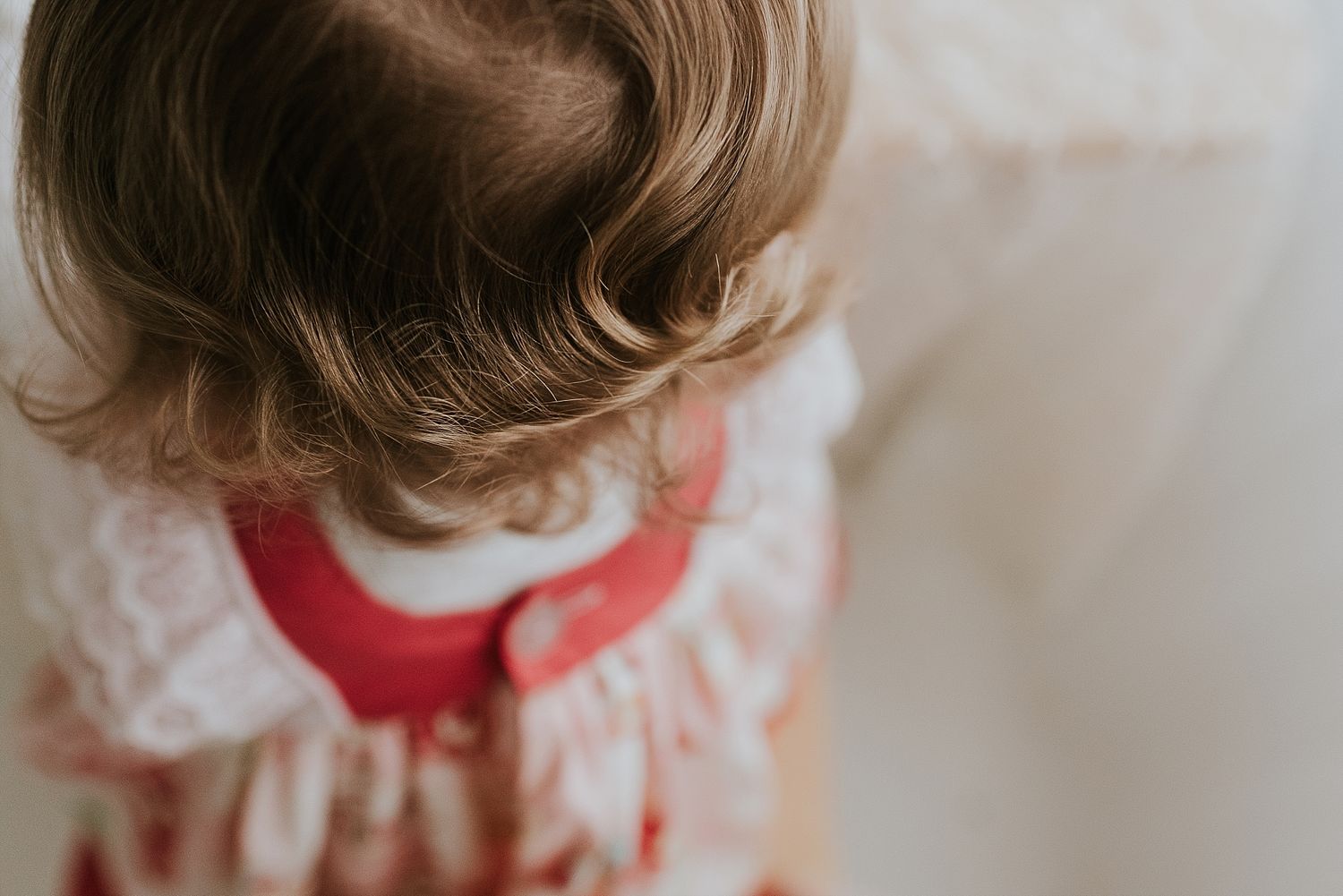 Overhead view of small child wearing a red and white dress from above.