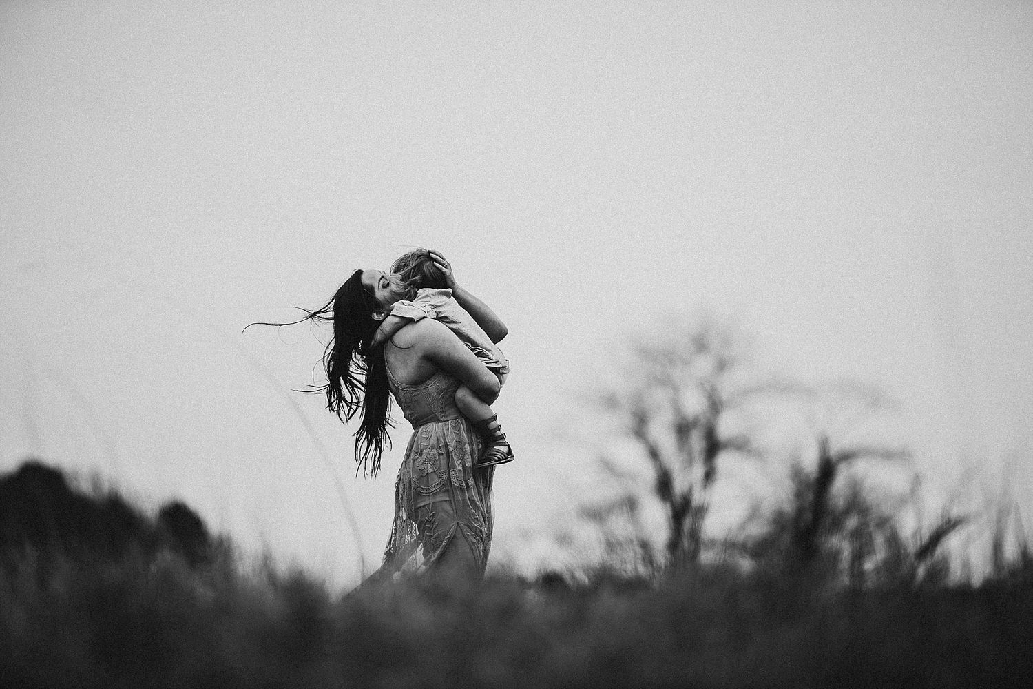 A silhouette of two people embracing against a misty background.