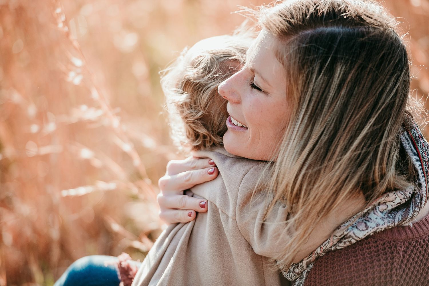 Tender embrace captured in warm golden light outdoors.